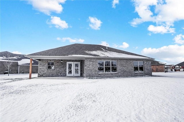 snow covered house featuring french doors