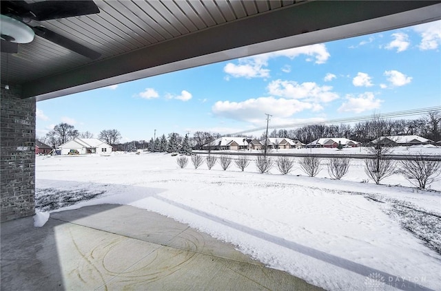 snowy yard featuring ceiling fan