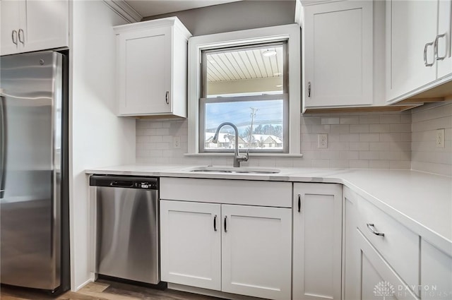 kitchen featuring white cabinets, decorative backsplash, sink, and appliances with stainless steel finishes