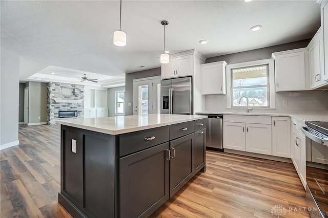 kitchen featuring pendant lighting, sink, ceiling fan, appliances with stainless steel finishes, and white cabinetry