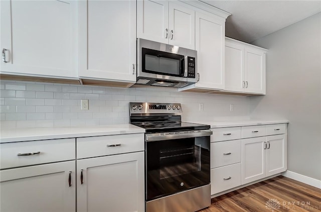 kitchen featuring backsplash, white cabinetry, stainless steel appliances, and dark wood-type flooring