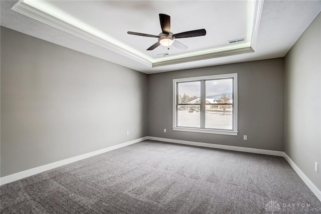 carpeted empty room with a tray ceiling, ceiling fan, and crown molding