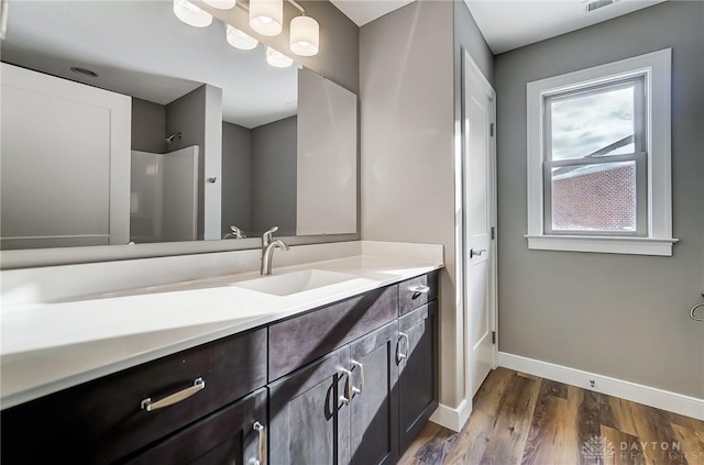 bathroom featuring hardwood / wood-style floors, vanity, and a shower