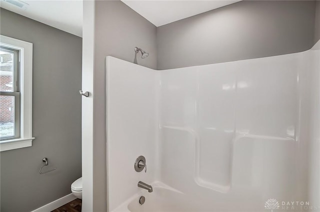 bathroom with shower / tub combination, toilet, and plenty of natural light