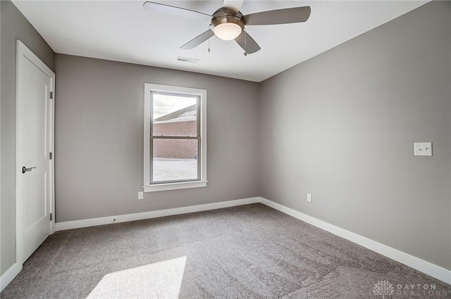 spare room with ceiling fan and carpet