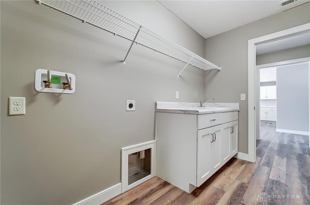 laundry room with hookup for an electric dryer, washer hookup, sink, and light hardwood / wood-style flooring