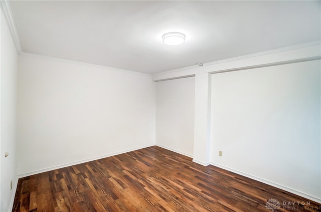 unfurnished room with crown molding and dark wood-type flooring