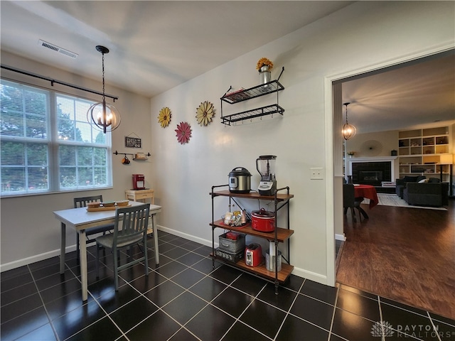 tiled dining room with a chandelier