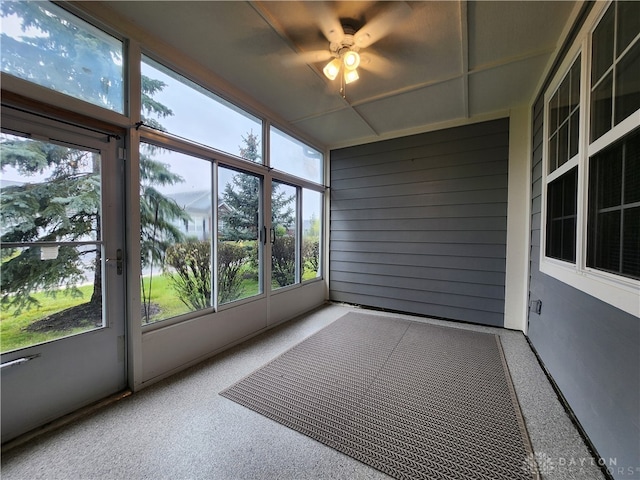 unfurnished sunroom featuring ceiling fan