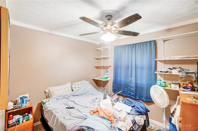 bedroom featuring ceiling fan, a textured ceiling, and crown molding