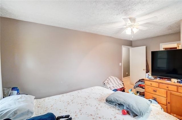 bedroom with ceiling fan and a textured ceiling