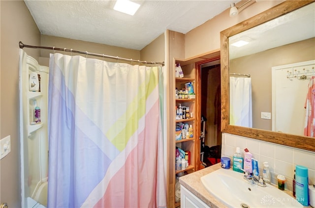 bathroom with vanity, a textured ceiling, and tasteful backsplash