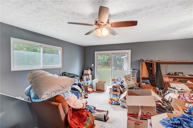 misc room with a textured ceiling, carpet flooring, and ceiling fan