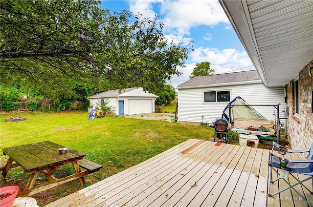 wooden deck with a garage, a lawn, and an outbuilding