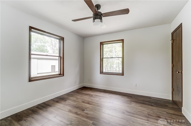 spare room featuring ceiling fan, dark hardwood / wood-style floors, and a wealth of natural light