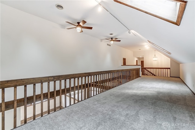 additional living space featuring carpet, ceiling fan, and vaulted ceiling with skylight