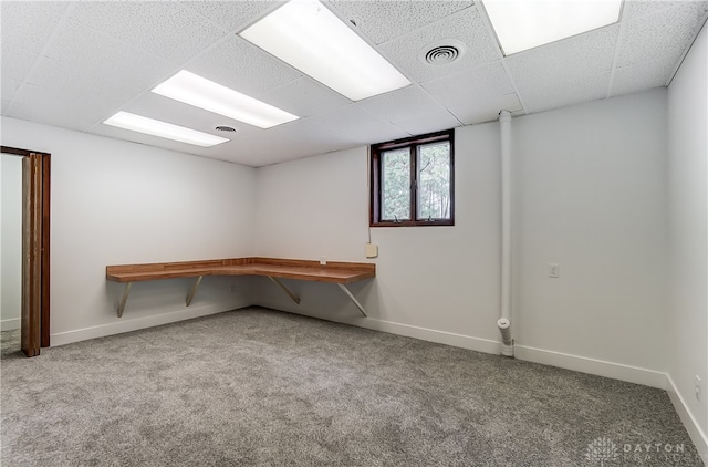 basement featuring a drop ceiling and carpet floors