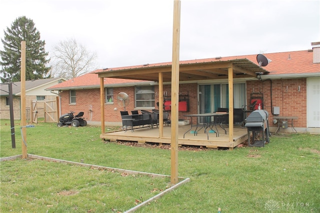 rear view of house featuring a deck and a lawn