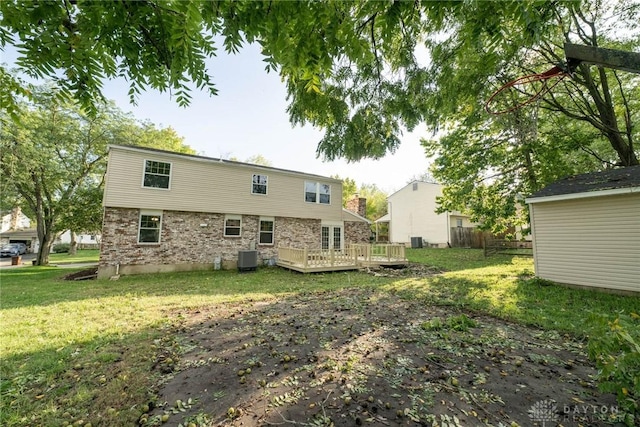 rear view of house featuring a yard, a wooden deck, and cooling unit