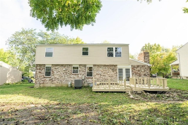 back of property featuring a lawn, a deck, and central AC