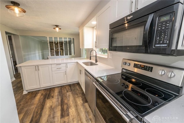 kitchen featuring appliances with stainless steel finishes, white cabinets, sink, and kitchen peninsula