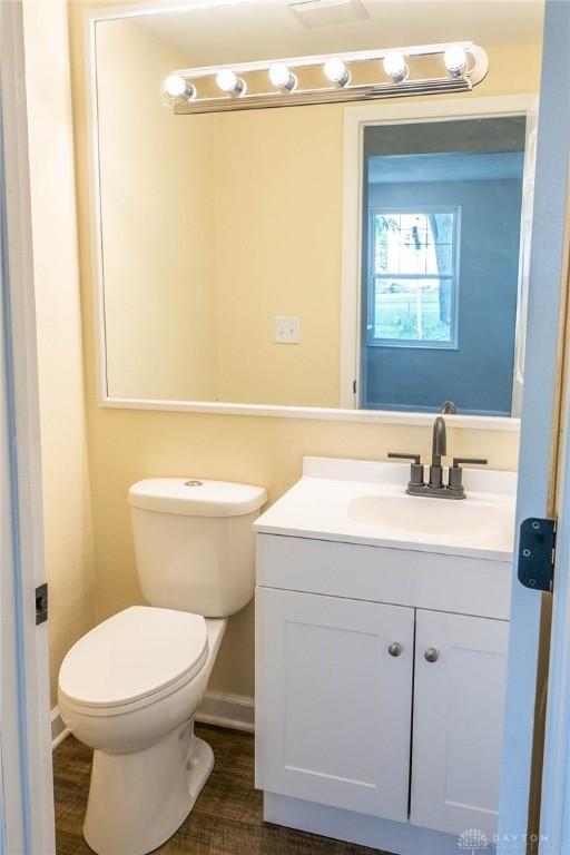 bathroom featuring toilet, hardwood / wood-style flooring, and vanity