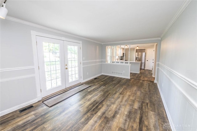 unfurnished living room featuring ornamental molding, dark wood-type flooring, and french doors