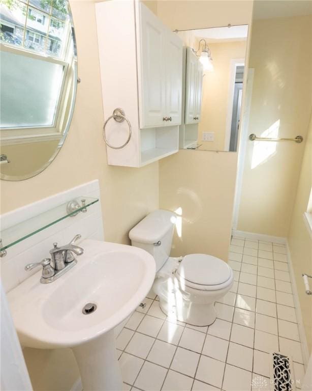 bathroom featuring toilet, tile patterned floors, and sink