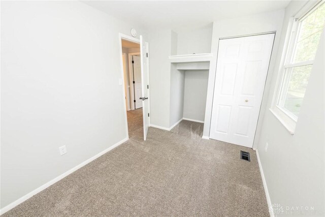 unfurnished bedroom with a closet and carpet floors