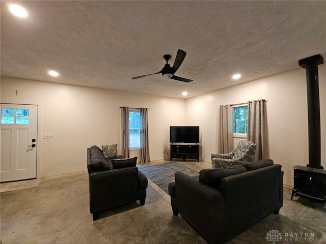 living room with a textured ceiling and ceiling fan