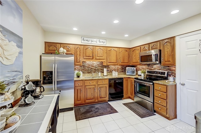 kitchen featuring light tile patterned floors, appliances with stainless steel finishes, sink, and decorative backsplash