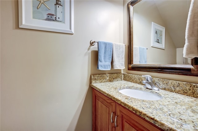 bathroom with lofted ceiling and vanity