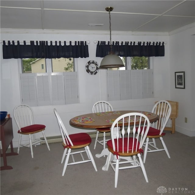 carpeted dining room with ornamental molding