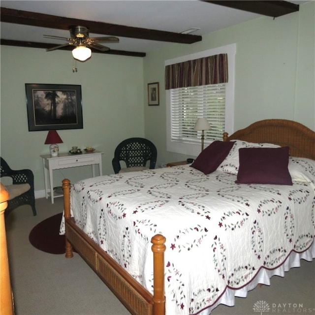 carpeted bedroom featuring ceiling fan and beamed ceiling