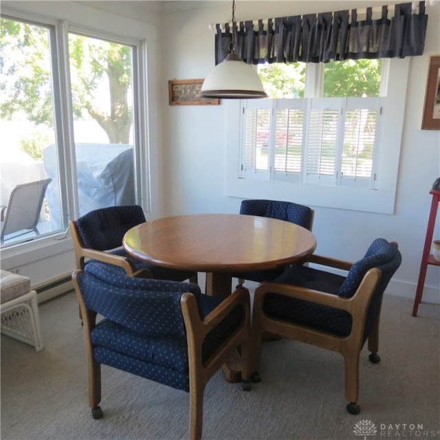 dining area featuring a baseboard heating unit and light colored carpet