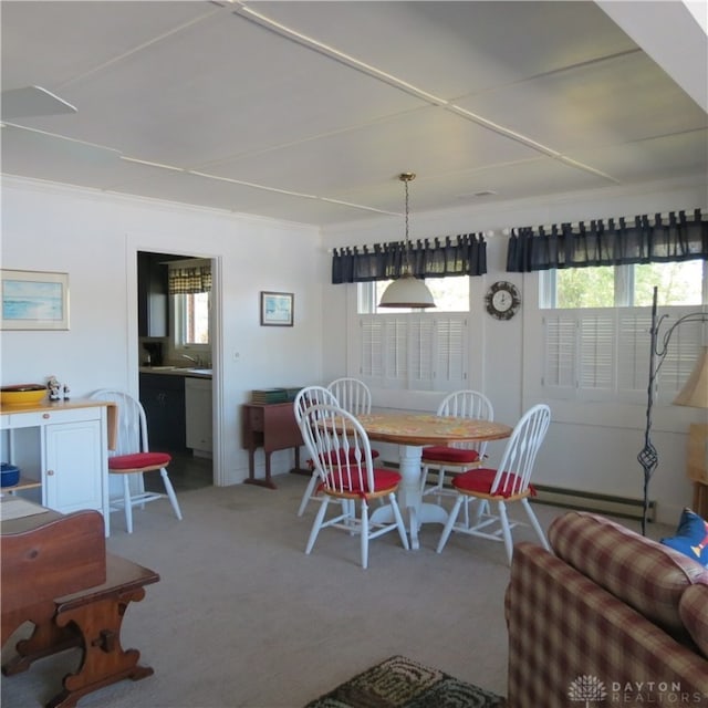 carpeted dining space featuring baseboard heating and crown molding