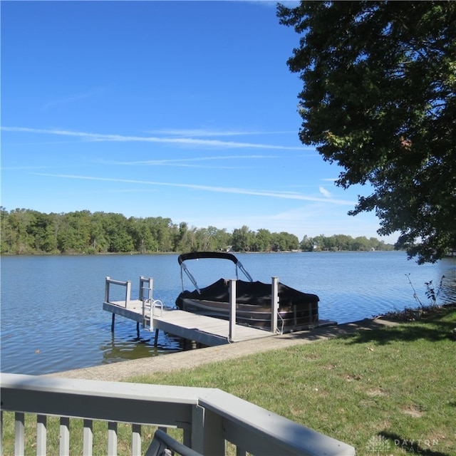 view of dock featuring a lawn and a water view