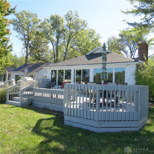 back of house featuring a lawn and a deck