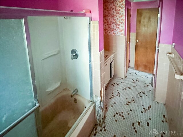 bathroom with enclosed tub / shower combo, tile walls, and tile patterned flooring