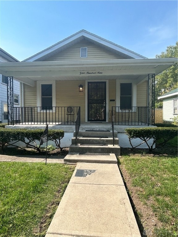 bungalow-style home featuring a porch and a front lawn