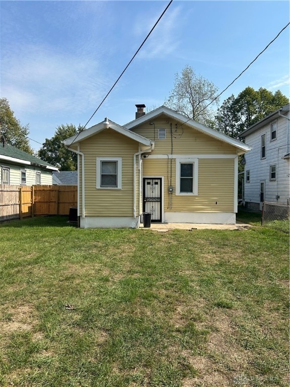 rear view of house with a patio and a lawn