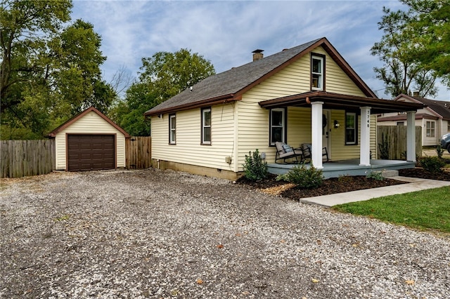 bungalow featuring a porch, a garage, and an outdoor structure