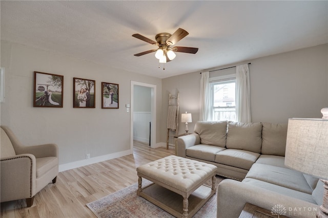 living room with ceiling fan and light hardwood / wood-style flooring