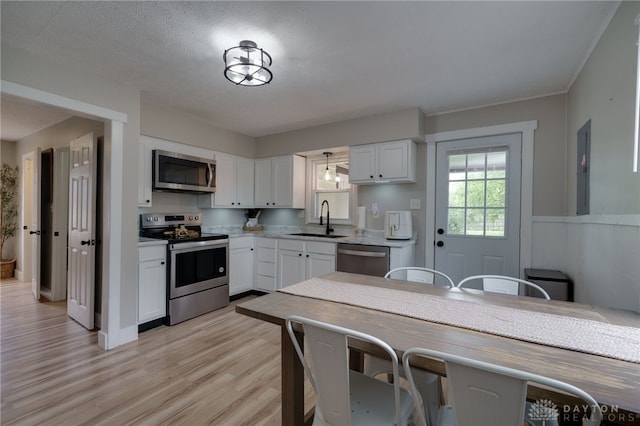 kitchen featuring sink, light hardwood / wood-style flooring, stainless steel appliances, and white cabinets