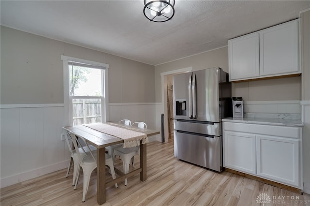 kitchen with white cabinetry, stainless steel fridge, light stone countertops, and light hardwood / wood-style floors