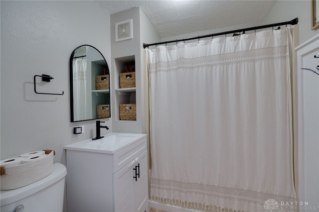 bathroom featuring vanity, a shower with curtain, toilet, and a textured ceiling