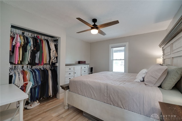 bedroom featuring ceiling fan, light hardwood / wood-style flooring, a textured ceiling, and a closet