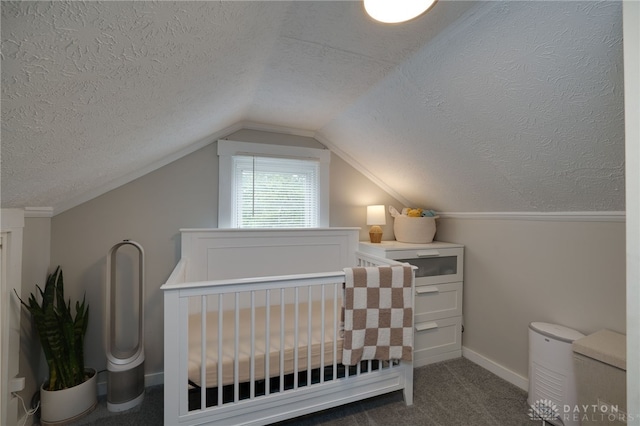 bedroom featuring a crib, vaulted ceiling, a textured ceiling, and dark colored carpet