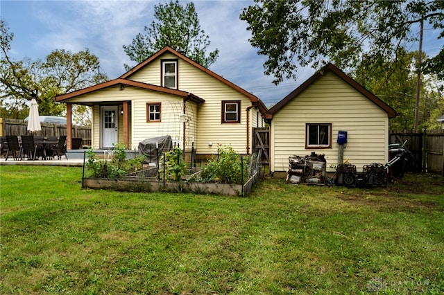 back of house featuring a lawn and a patio