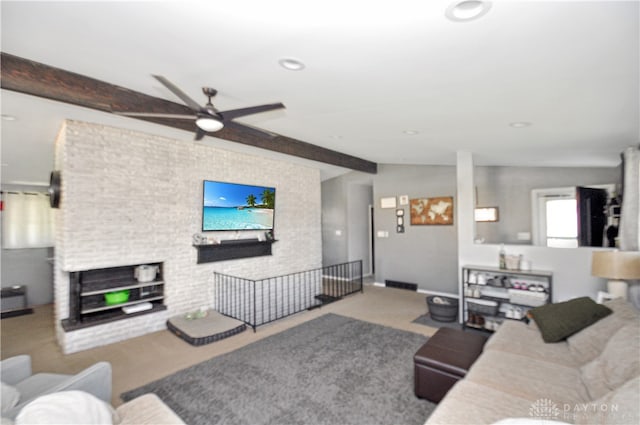 living room featuring lofted ceiling with beams, ceiling fan, light colored carpet, and a fireplace